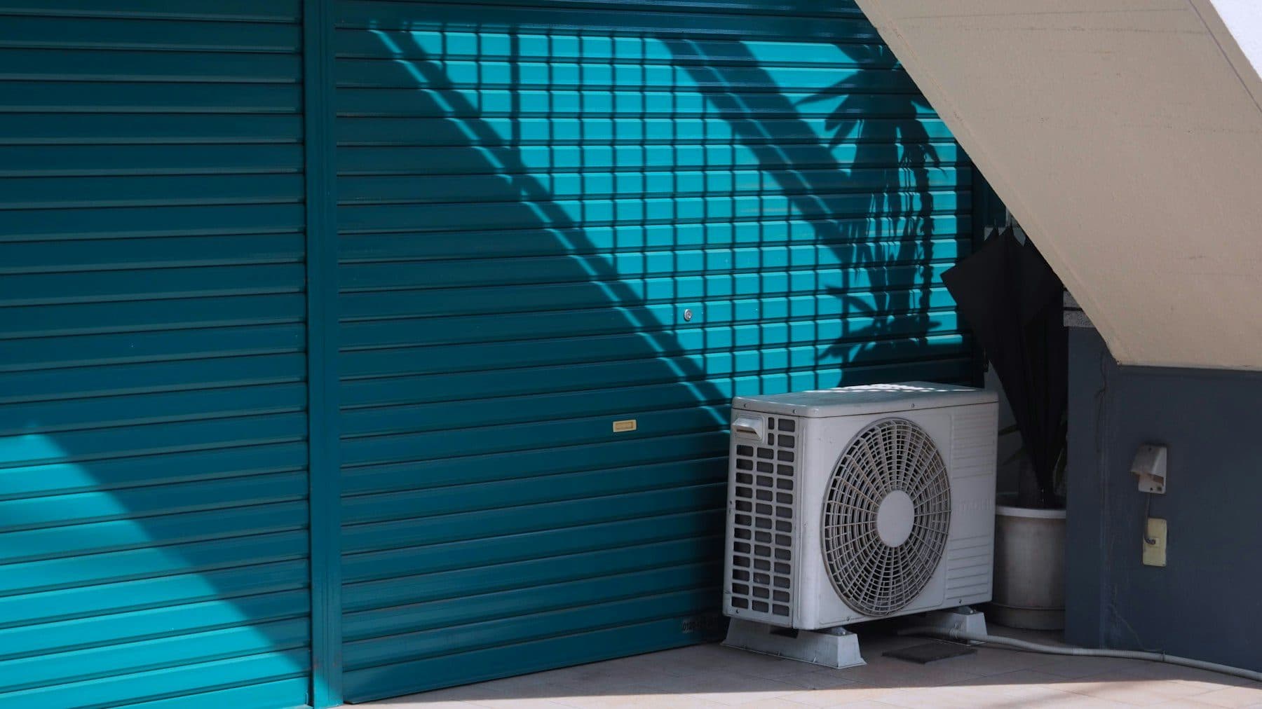 Air conditioning unit mounted outside a teal building