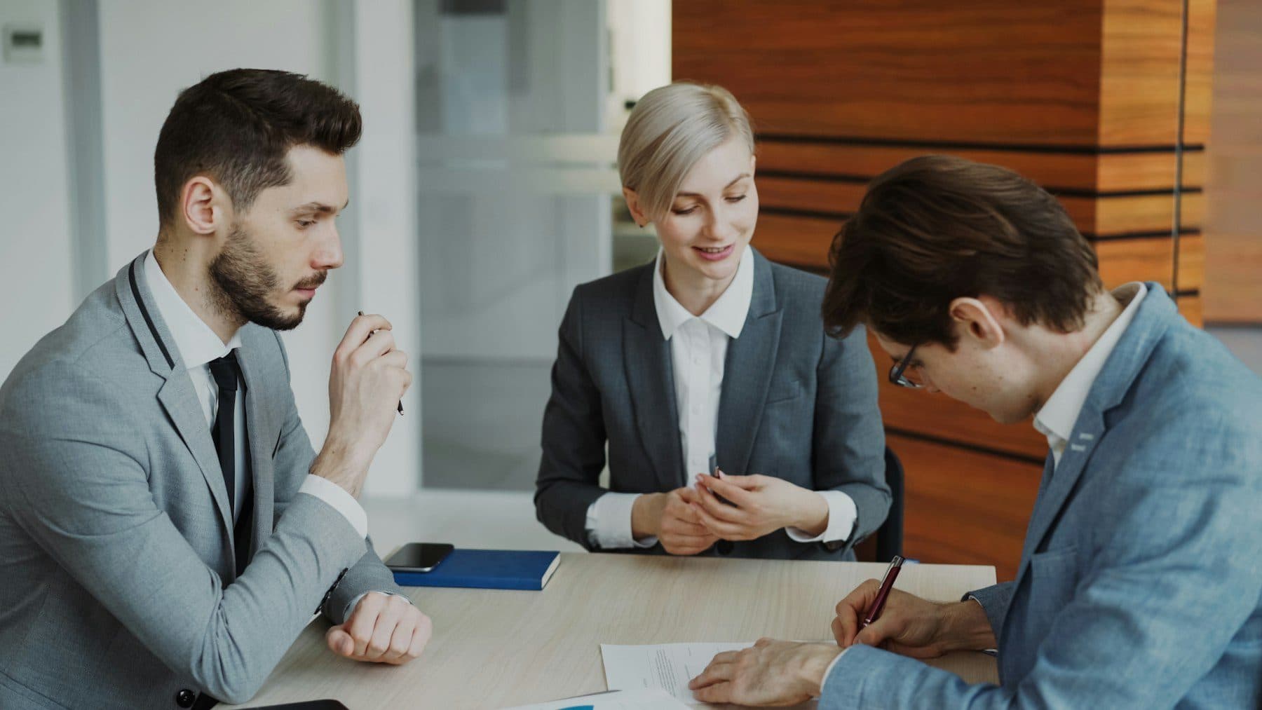 Professionals reviewing and signing documents at a table